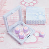 A clear plastic case holds purple silicone cat paw keycaps and a box labeled Cat Claw Keycap for MX Switches on a pink backgr