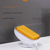 A yellow leaf-shaped suction cup soap dish is shown on a white countertop, featuring a 45-degree incline design.