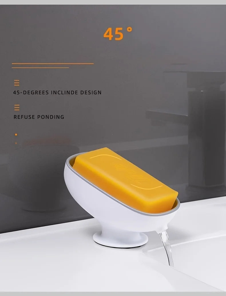 A yellow leaf-shaped suction cup soap dish is shown on a white countertop, featuring a 45-degree incline design.