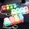 A set of colorful LED macaron keyboard fidget toys with metal keychains displayed on a dark surface.