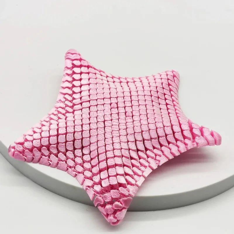 A pink 3D printed articulated starfish fidget toy with a textured, woven surface.