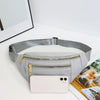 A light gray nylon waist pack with a zippered pocket and a smartphone attached, resting on a white surface.