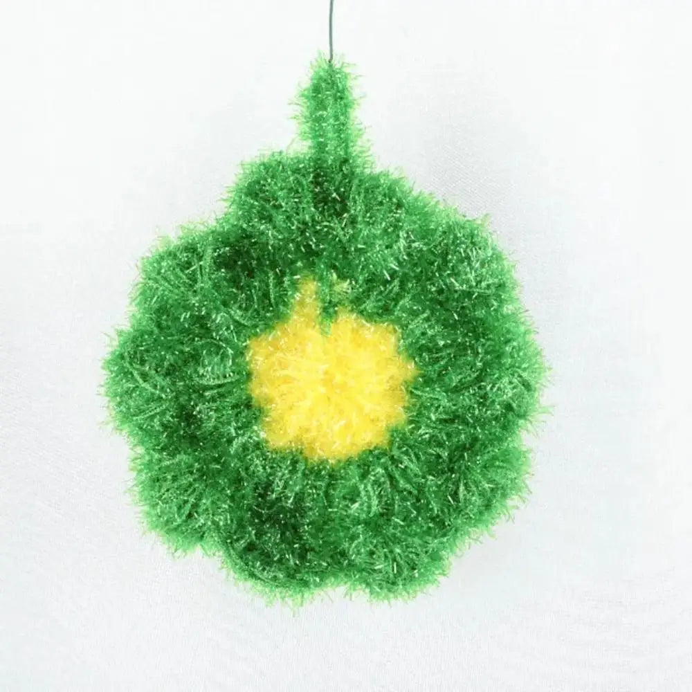 A bright green, fluffy dish sponge with a yellow center hanging from a string.