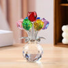 A crystal sculpture featuring a bouquet of colorful, reflective glass roses displayed in a clear base.