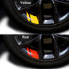 Close-up view of a black wheel hub with yellow and red reflective stickers applied to the spokes.