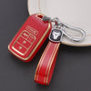 A red TPU protective key case with a silver keychain attached, resting on a dark surface.