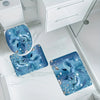 A set of three blue dolphin-themed bathroom mats featuring sparkling designs on a white marble floor.