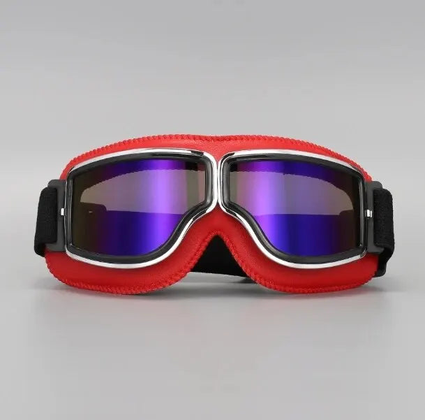A pair of red retro foldable motorcycle goggles with a black strap and purple-tinted lenses.
