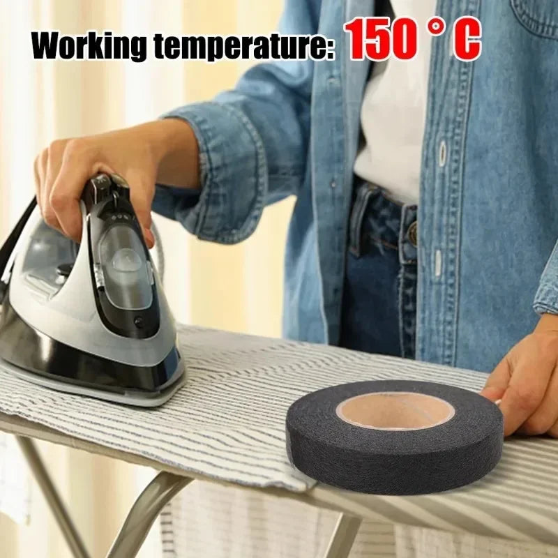 A hand is applying double-sided iron-on fabric adhesive tape onto a gray ironing board surface.