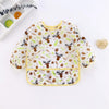 A yellow and white kids waterproof long sleeve art smock and feeding bib with a nature-themed pattern.