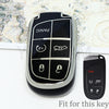 A black durable TPU car key fob cover with panic and unlock buttons displayed on a white surface.