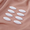 Eight oval white scarf pins arranged on a soft pink fabric.