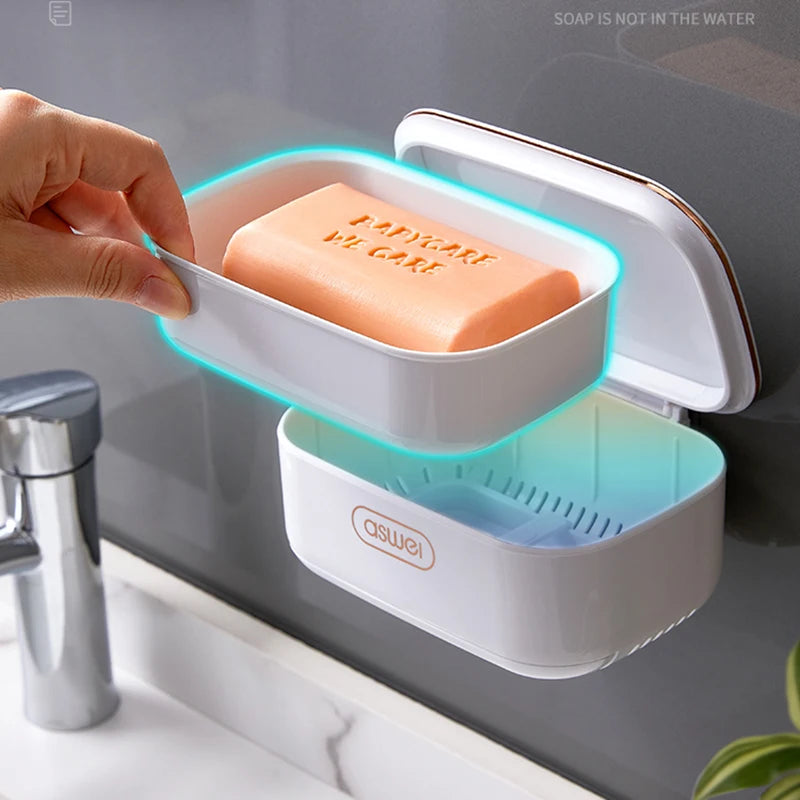 A hand places a block of orange soap into a two-tier draining soap holder with blue LED lighting.