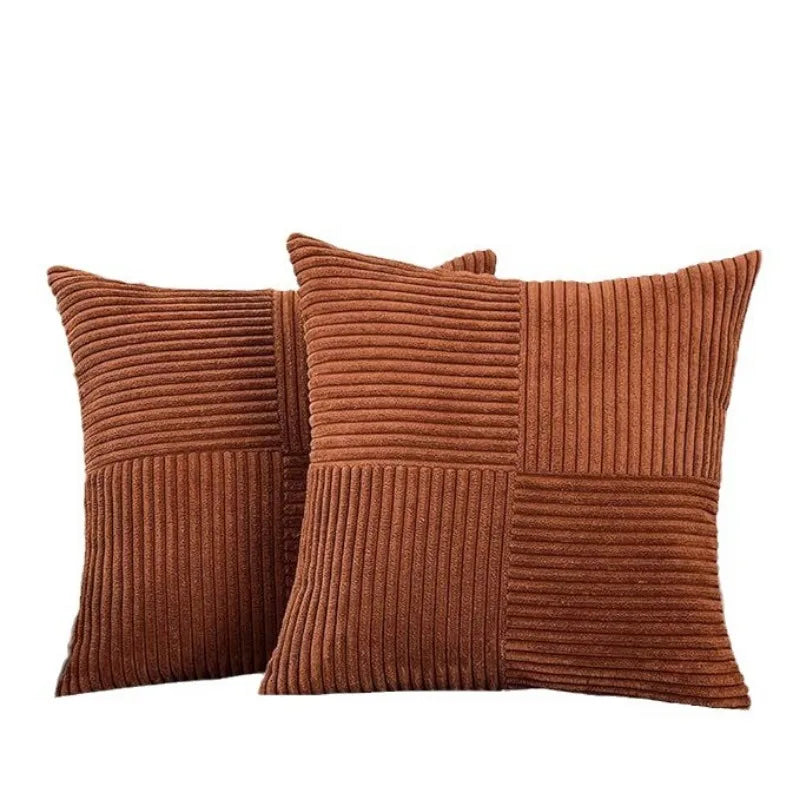 A set of two rust-colored corduroy patchwork throw pillow covers with vertical ribbing.