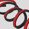 A close-up view of a black and red 3-layer rubber door seal strip coiled on a light gray background.