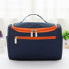 A navy blue hanging makeup bag with an orange trim is displayed on a white surface.