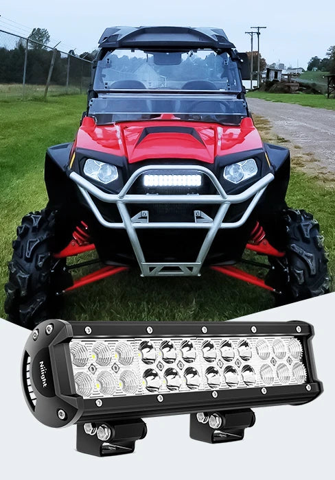A close-up view of a black LED flood light pod mounted on the front of a red truck or SUV.
