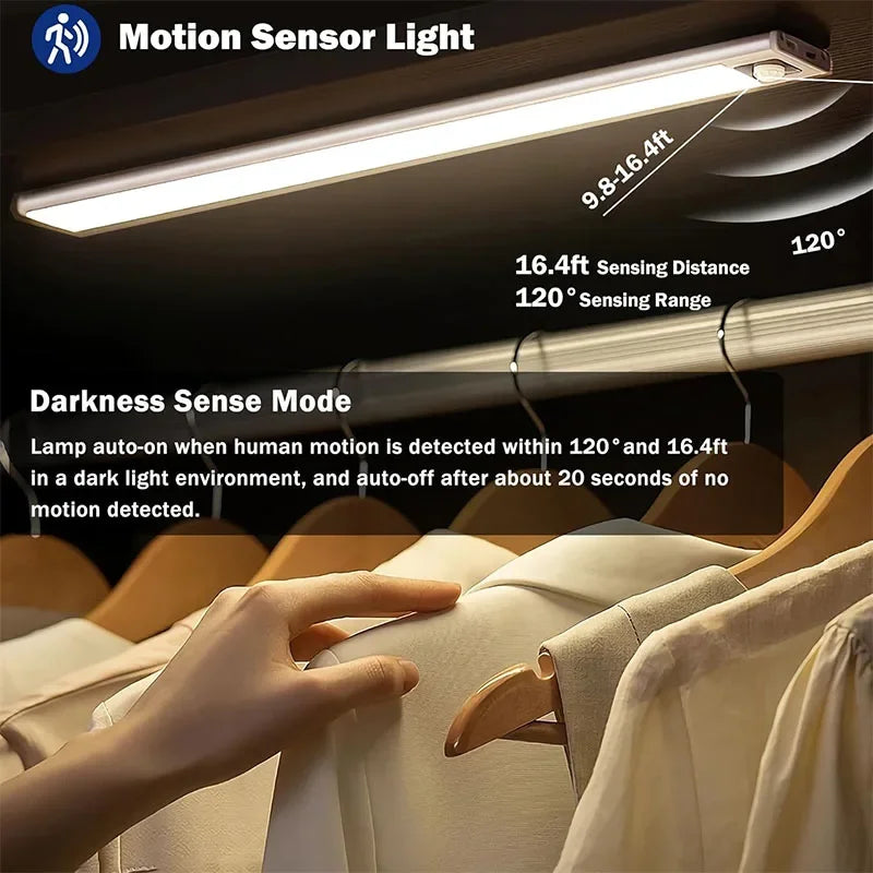 A hand is touching a light-colored garment in a closet, illuminated by an overhead motion sensor light.