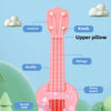 A pink mini ukulele toy guitar with strings and a sound hole is shown against a light blue background.