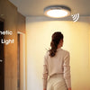 A woman stands near a modern staircase with a rechargeable and magnetic motion sensor ceiling light installed above.