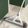 A white silicone squeegee broom is shown cleaning a light-colored floor next to a dark green cabinet.