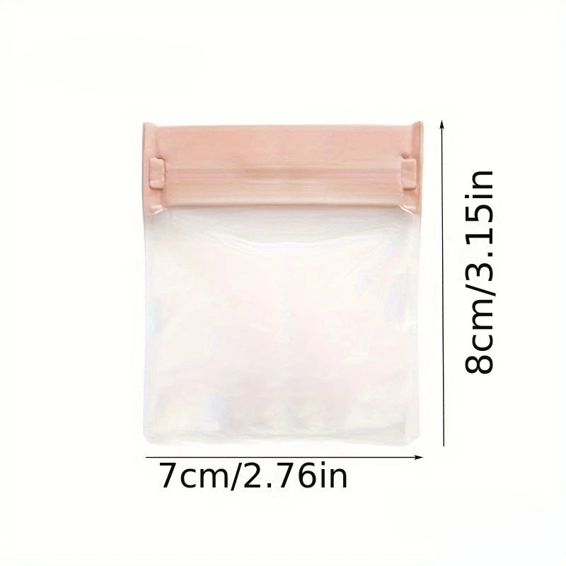 A clear, self-sealing cosmetic bag with a pink/nude colored seal and dimensions of 8cm by 7cm.