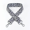 A black and white leopard print wide adjustable crossbody bag strap.