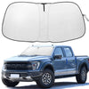 A white windshield sunshade is shown open, next to a blue Ford F150 pickup truck.