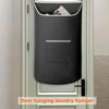 A gray hanging laundry hamper is mounted on a white door with a rectangular window.