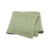 A light sage green knitted soft cotton baby blanket with small eyelet holes.