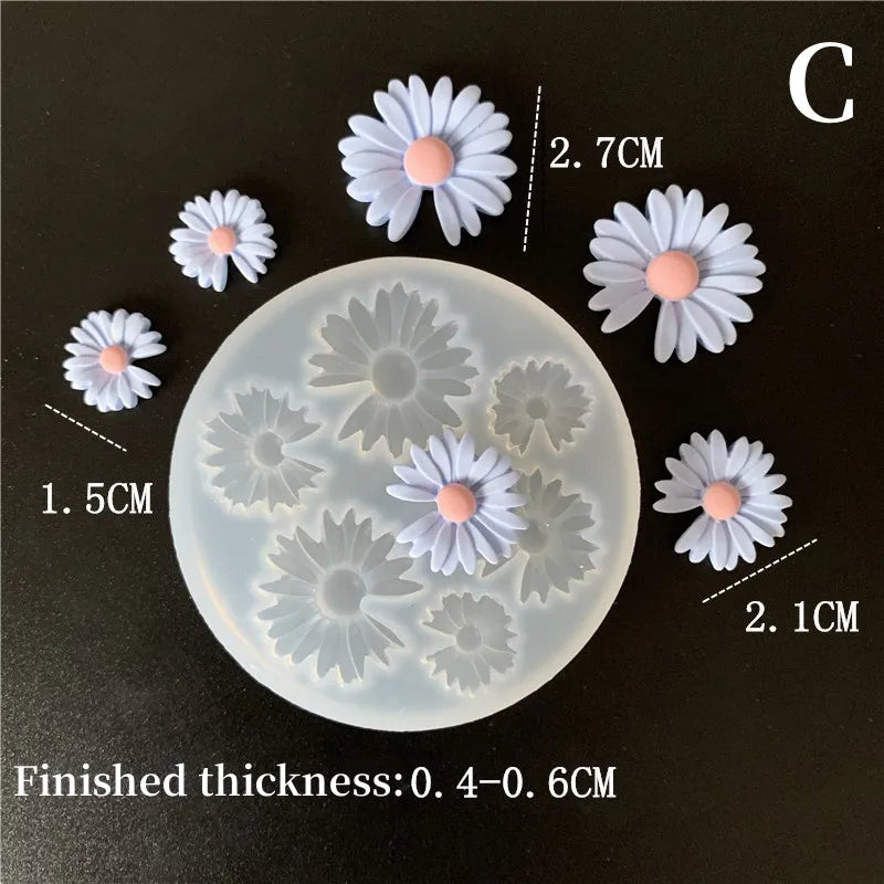 Silicone molds of daisies in various sizes are displayed on a dark surface.