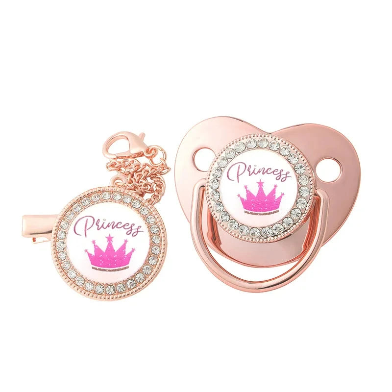 A rose gold crystal rhinestone pacifier chain clip set with silicone nipple and crown charm.