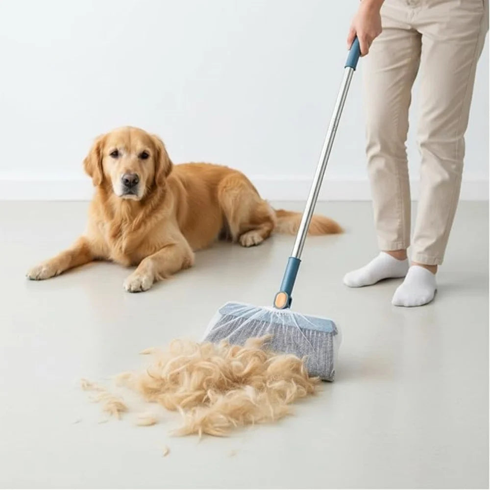 A person is using a long handle broom to sweep loose dog hair on a light-colored floor.