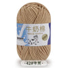 A ball of beige milk cotton blend yarn with a label in Chinese and English.