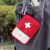 A red and white first aid kit pouch hangs from a gray fabric tote bag.