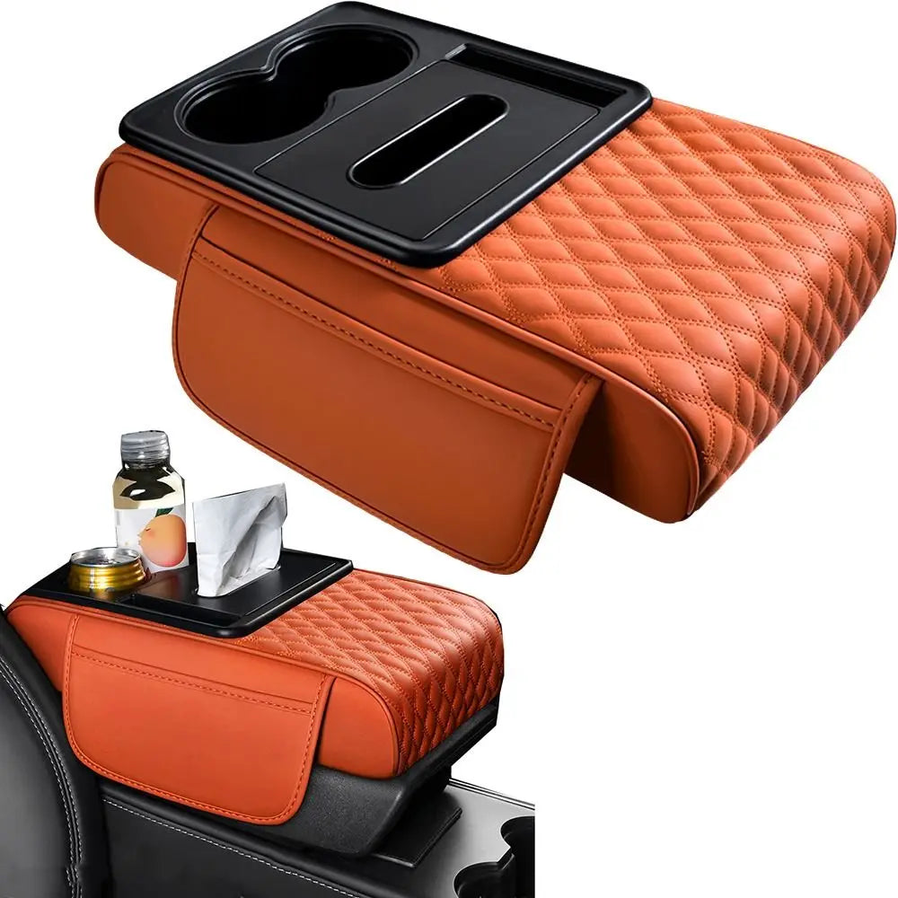 An orange quilted car armrest cushion with storage compartments and cup holders is shown on a black vehicle interior.