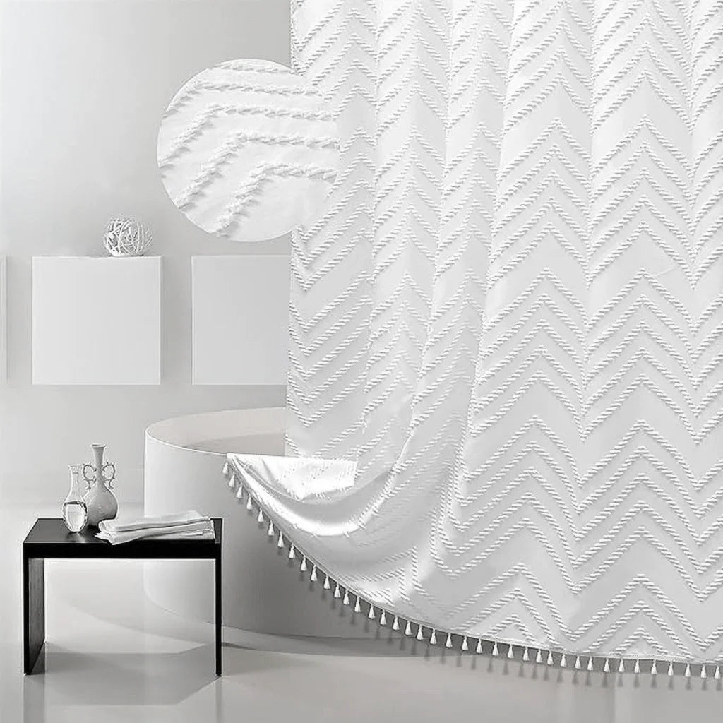 White boho waterproof shower curtain with a chevron pattern and tassels hanging in a modern bathroom setting.