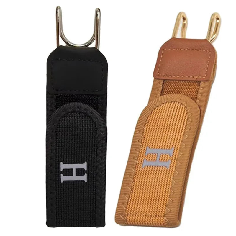 A black adjustable buckleless hook belt with a tan leather strap and silver hardware.