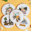 A set of five embroidery hoops featuring pre-printed floral and cat designs on white fabric.