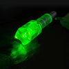 A bright green LED archery arrow nock with a multi-size adapter glowing on a dark surface.