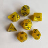A collection of seven yellow polyhedral dice scattered on a white surface.