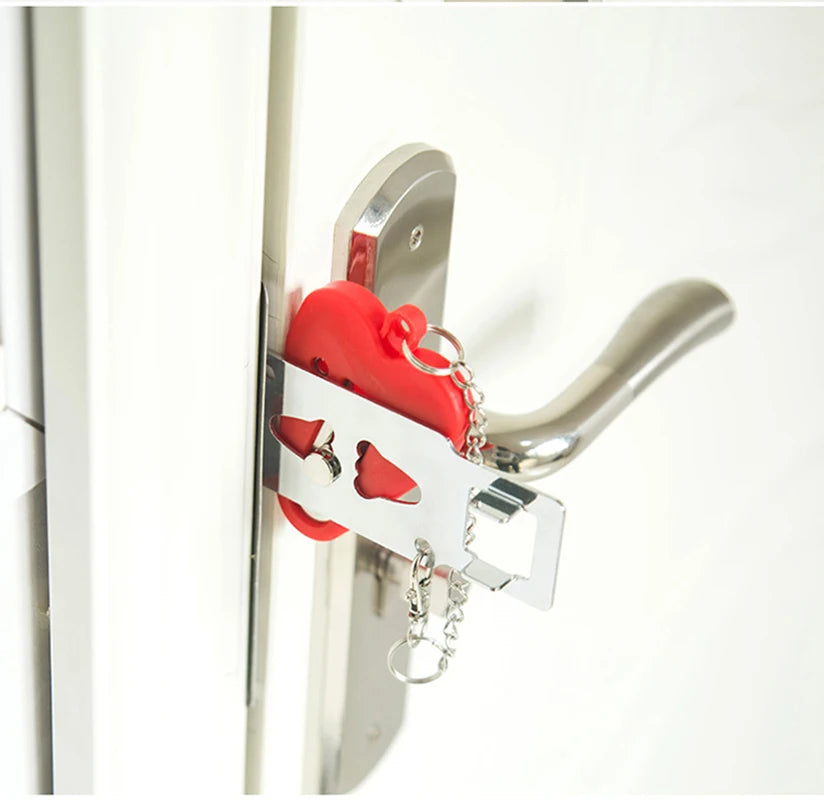 A portable door security lock with a red handle and silver latch is mounted on a white door frame.