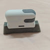 A white and gray multi-purpose crevice cleaning brush resting on a piece of gray foam.