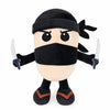 A black and tan plush toy of a shark character with a mask and small blades.
