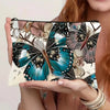 A canvas charger storage pouch featuring a detailed butterfly print in shades of teal, black, and beige.