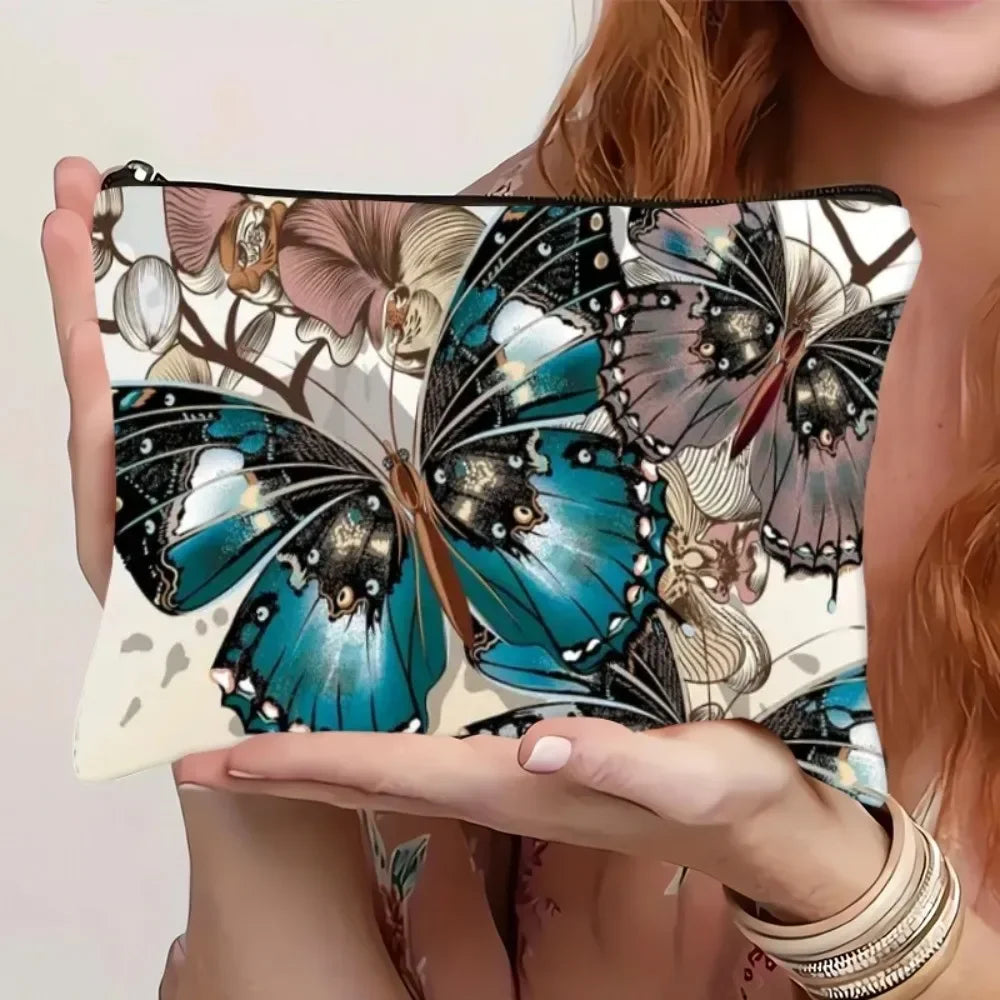 A canvas charger storage pouch featuring a detailed butterfly print in shades of teal, black, and beige.