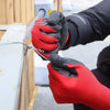A hand wearing red work gloves is gripping a wire attached to a wooden structure.