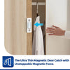 A hand is shown engaging an ultra-thin magnetic door catch on a wooden cabinet door.