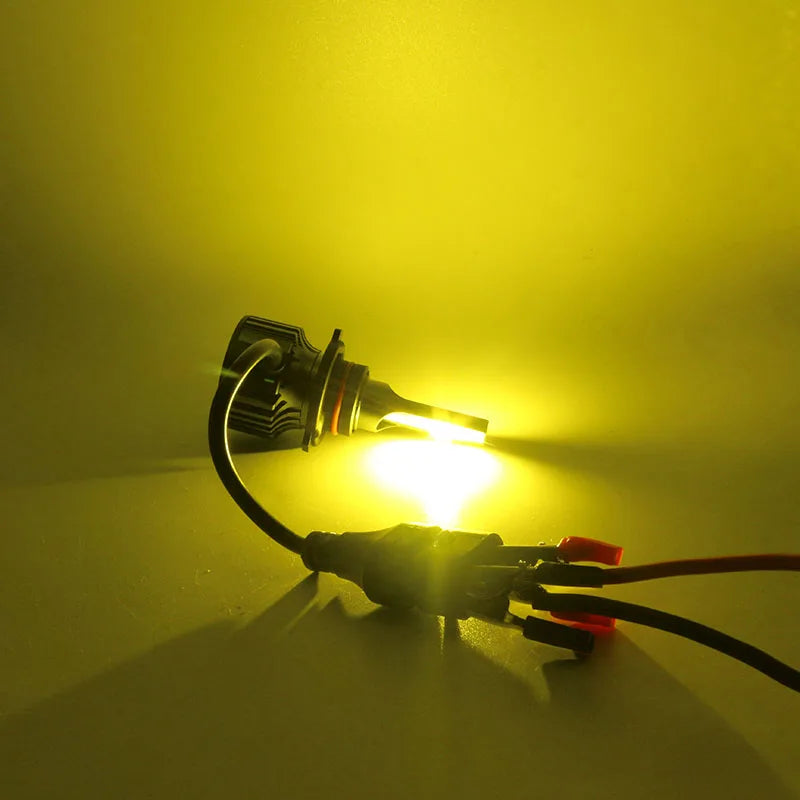 A bright LED headlight bulb with a visible cooling fan is illuminated against a dark background.