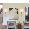 Two modern wall sconces with light bulbs mounted on a white wall in a contemporary interior.